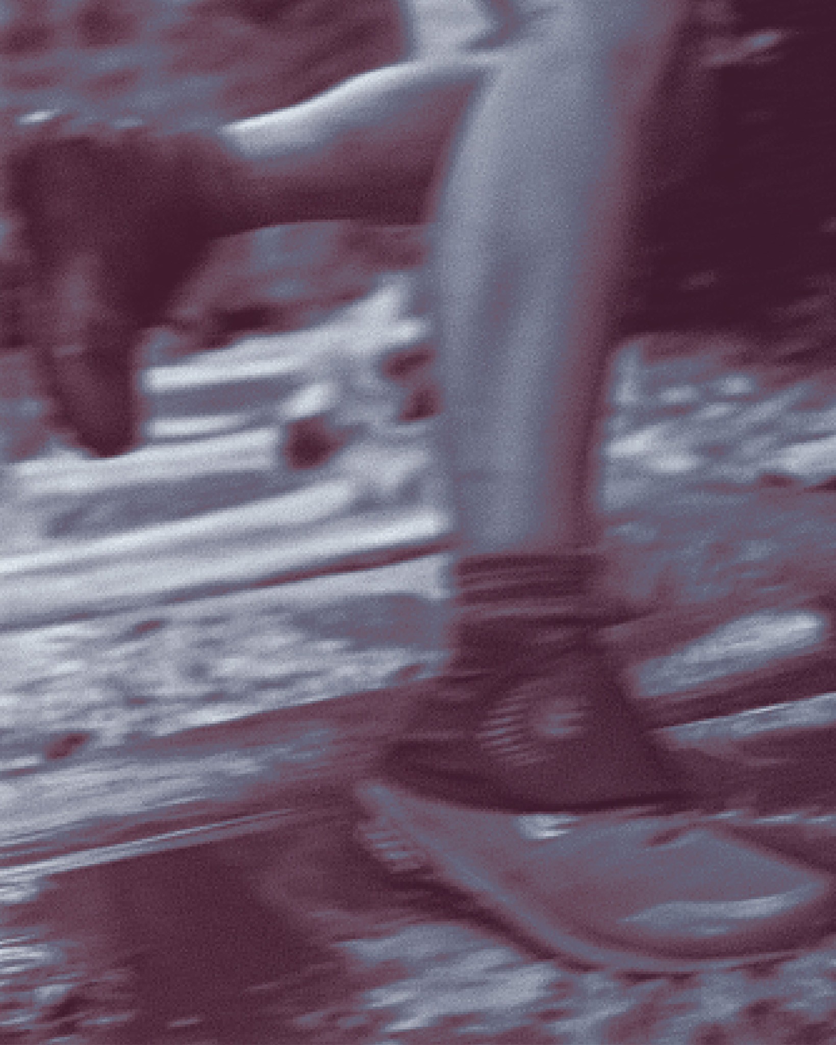 A person wearing Topo gaiters running through a stream