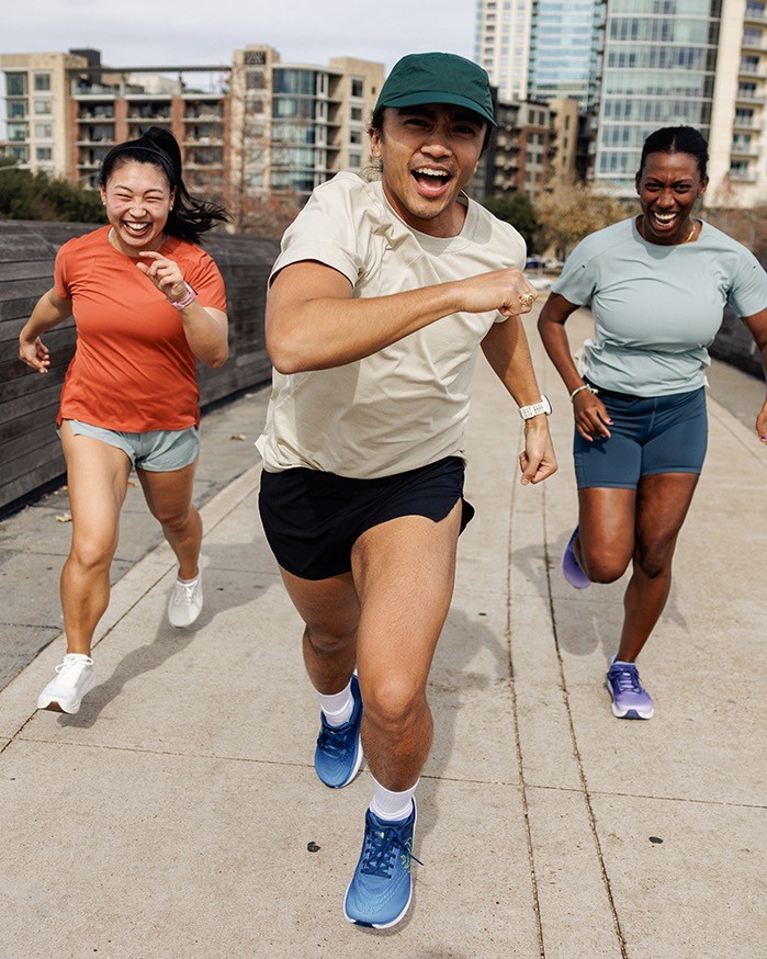 People smiling and running outside in the city